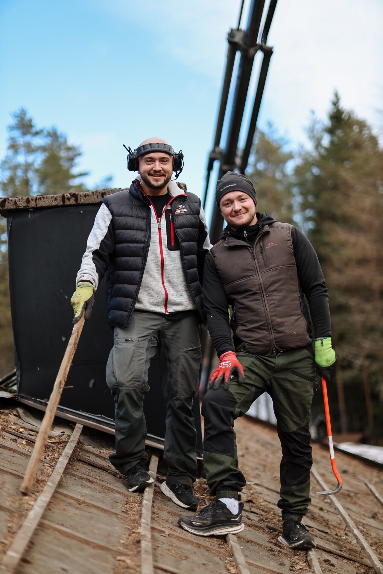 Två personer med skyddsutrustning under takarbete
