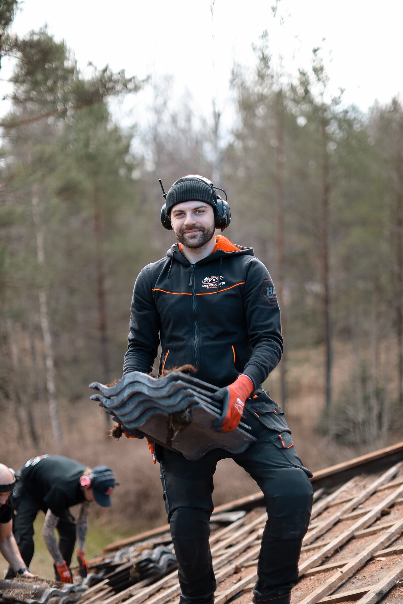 Person i arbetskläder under takarbete