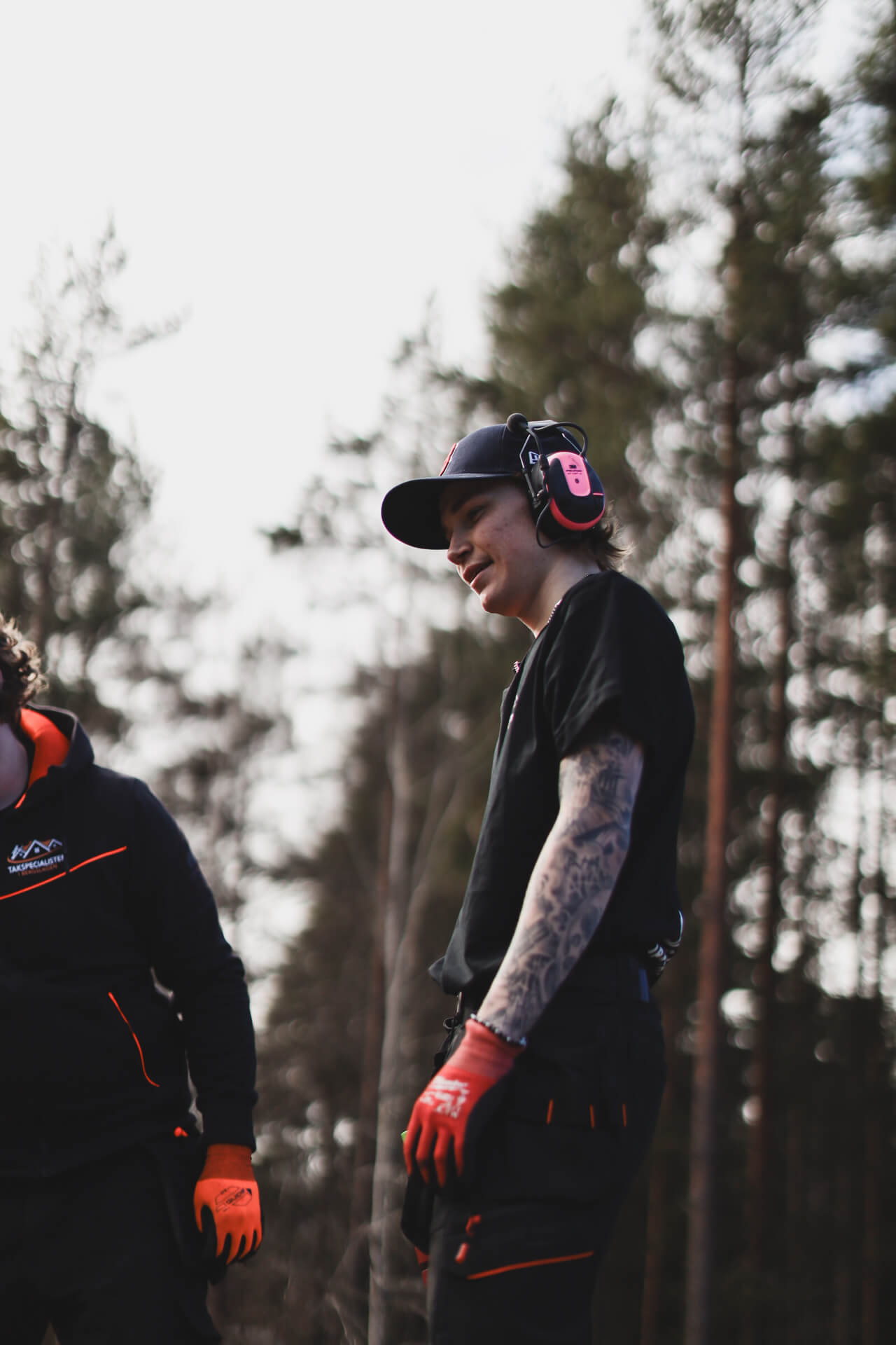 Person med hörselskydd och arbetskläder utomhus