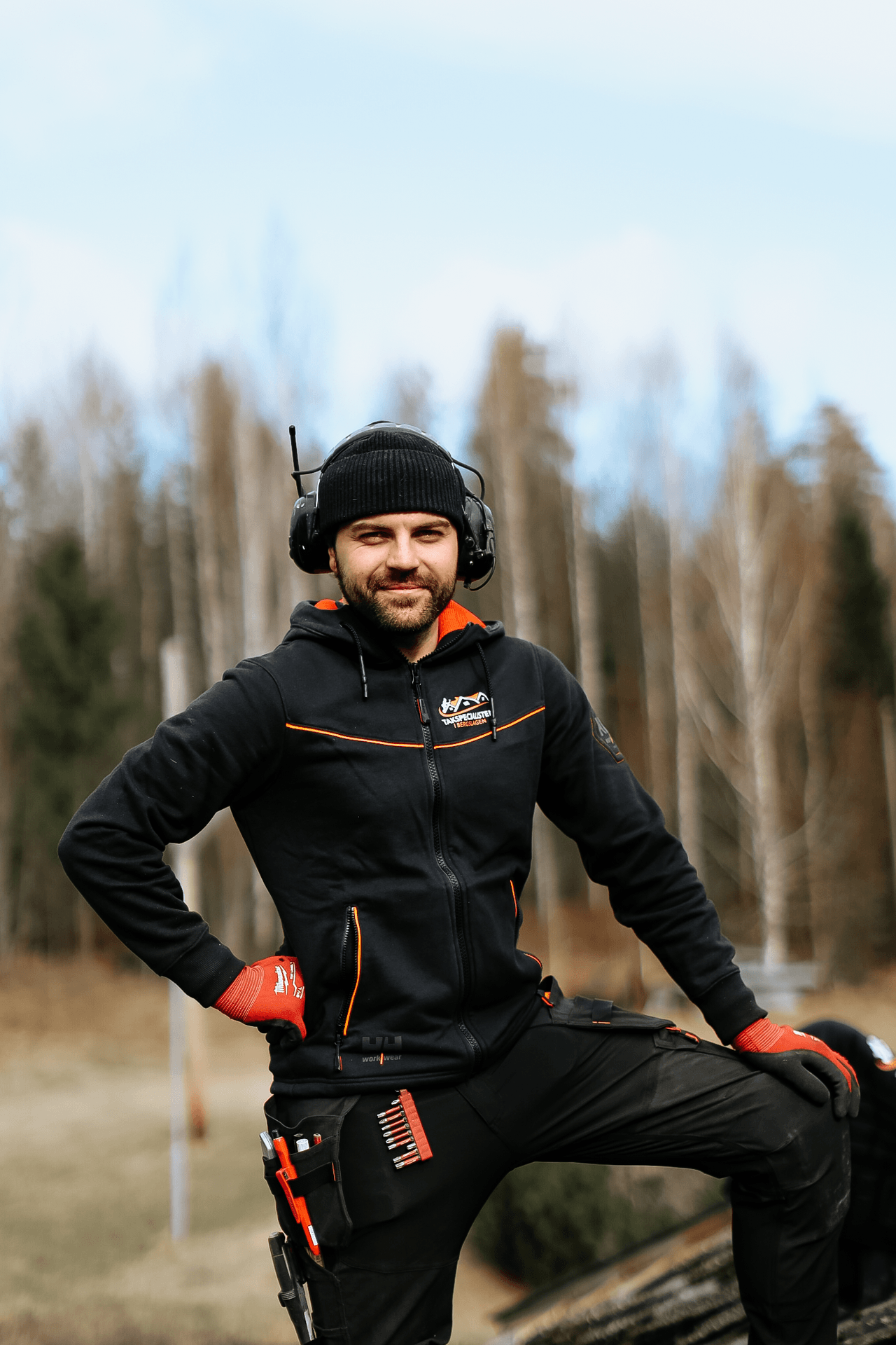 Person i arbetskläder med hörselskydd utomhus