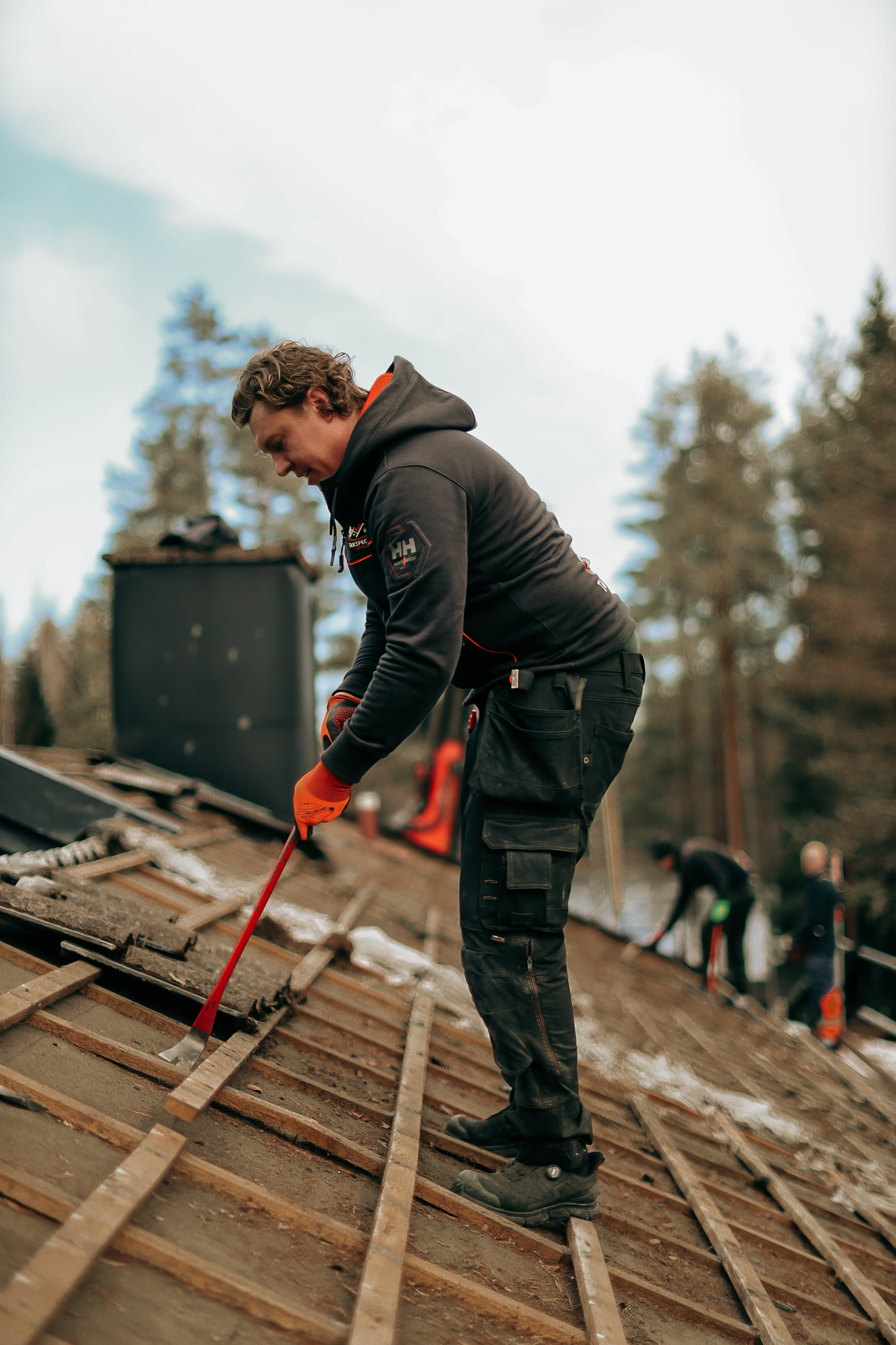 Takarbetare med handverktyg under renovering