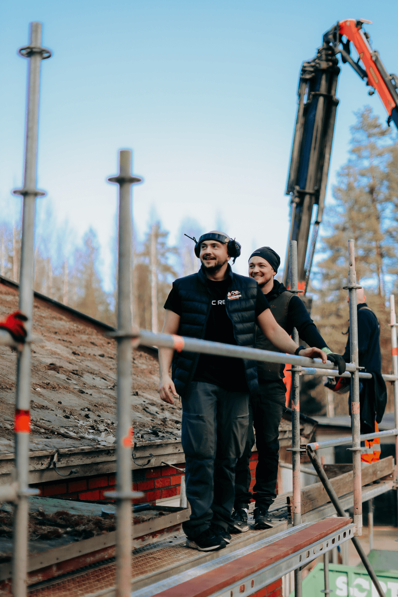 Två personer i arbetskläder under takarbete