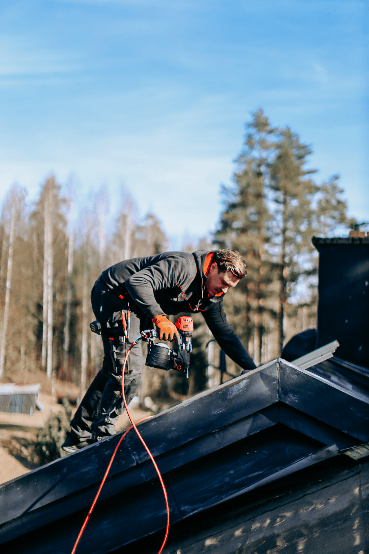 Person som utför takarbete med spikpistol