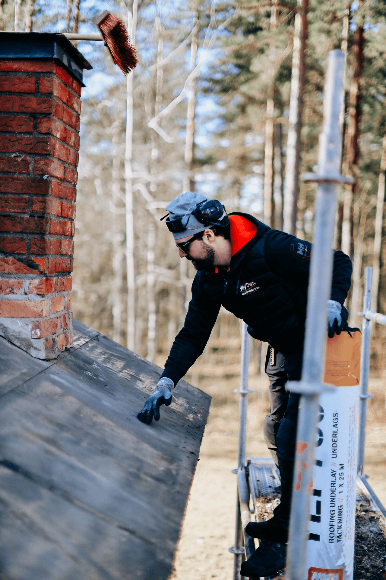 Takarbetare som utför arbete runt en skorsten
