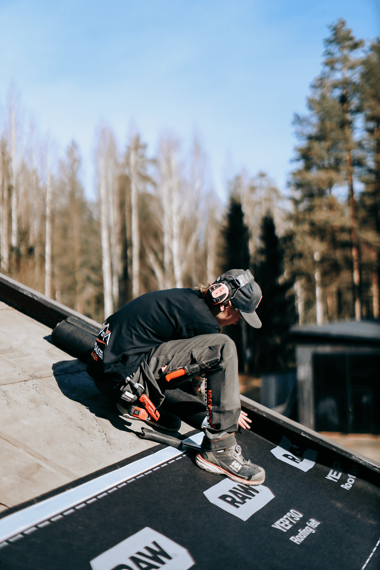 Person som arbetar med takläggning på ett hustak