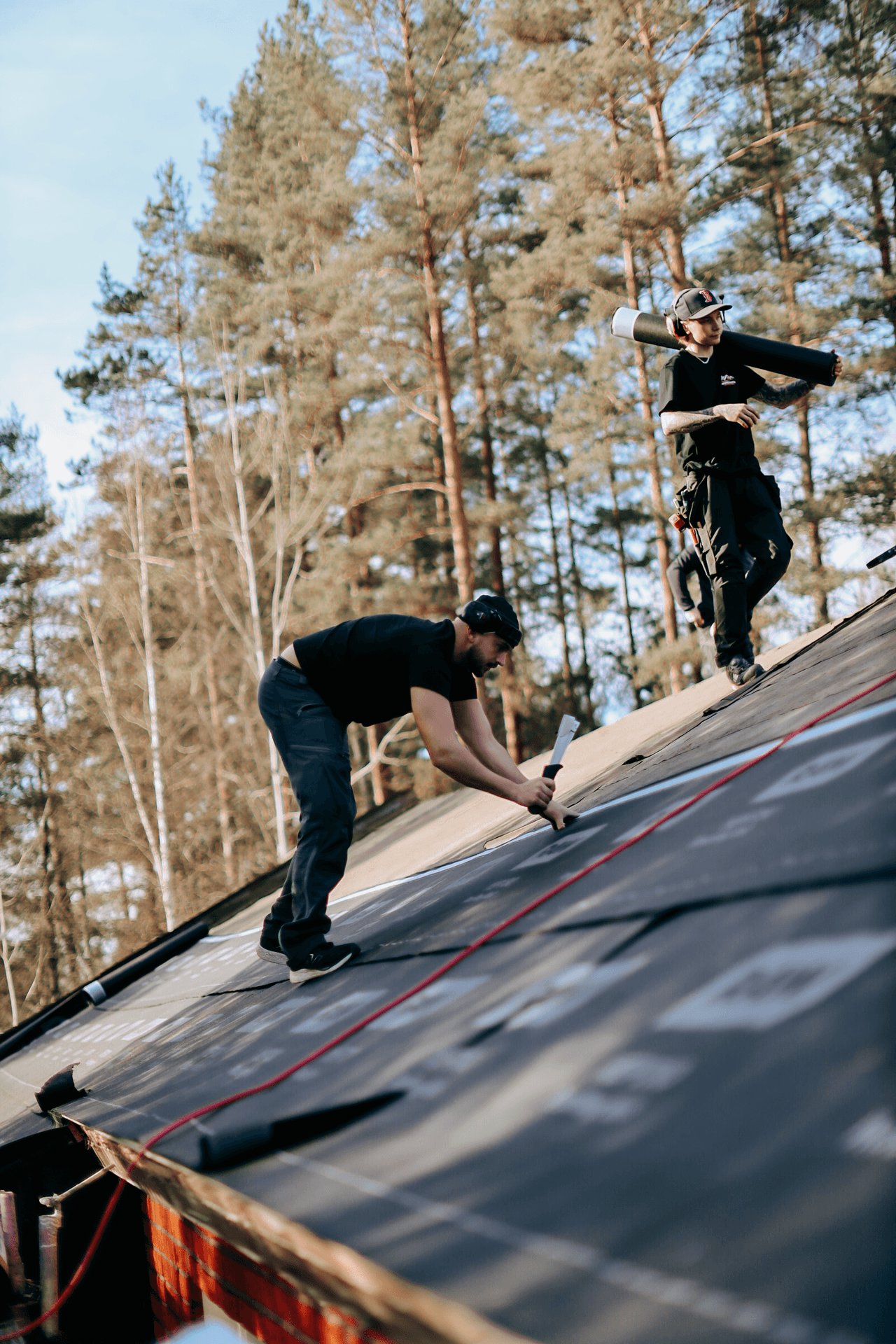 Takläggare som monterar takmaterial på ett hustak