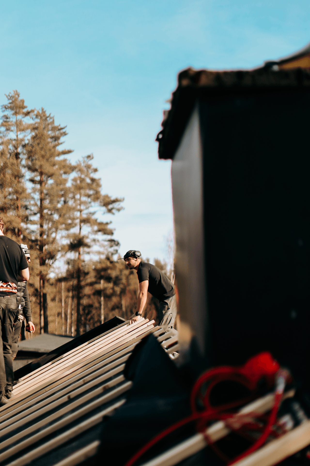 Hantverkare som bär byggmaterial vid takarbete