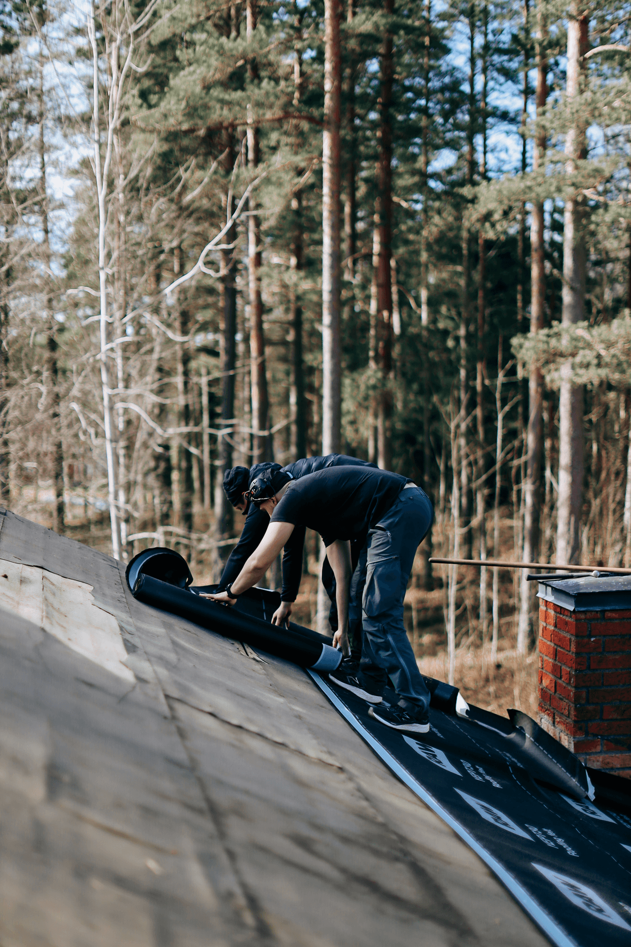 Personer som installerar takmaterial vid en skorsten