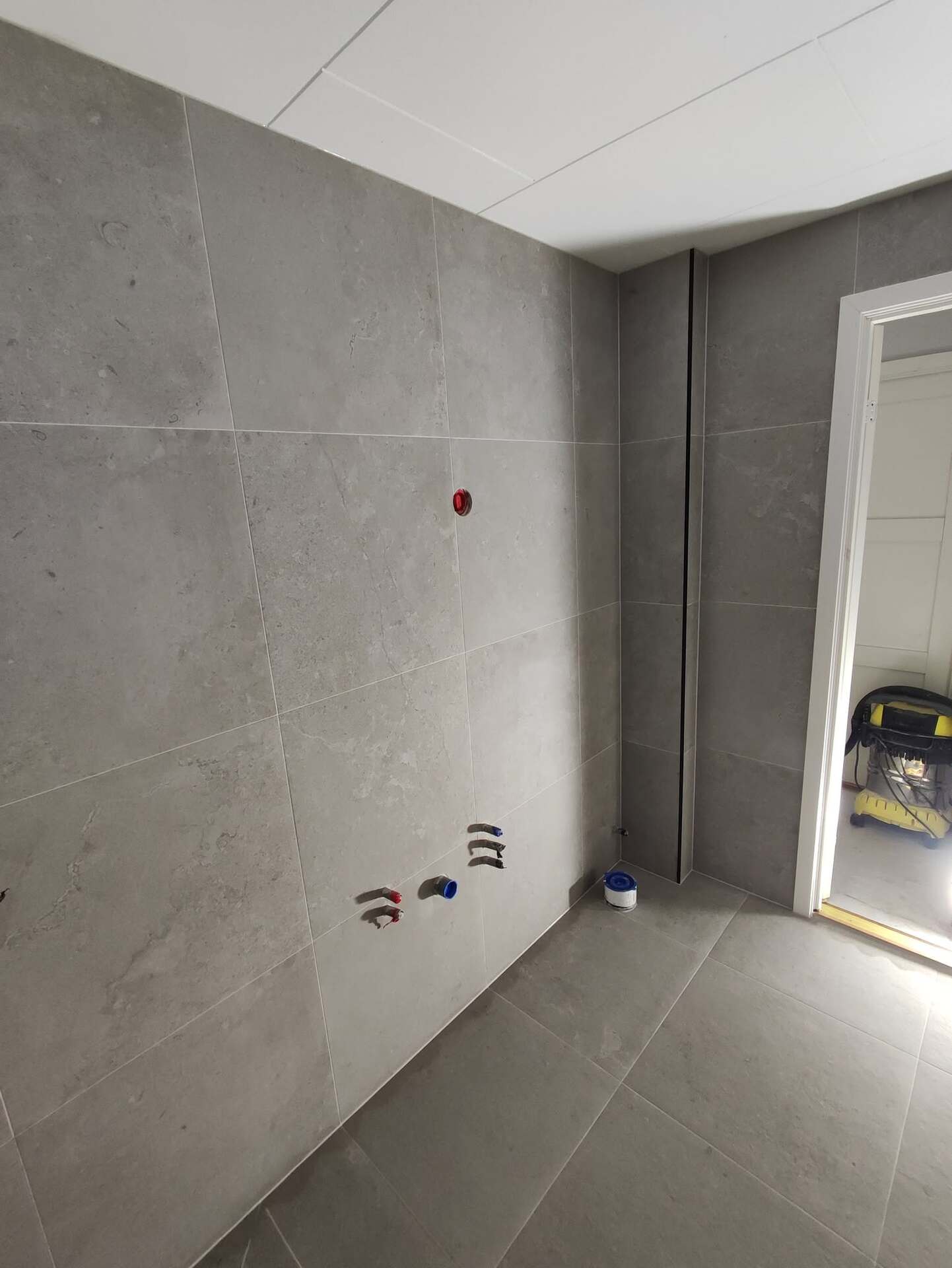 Nylagd kakelplattsättning på vägg i badrum under renovering