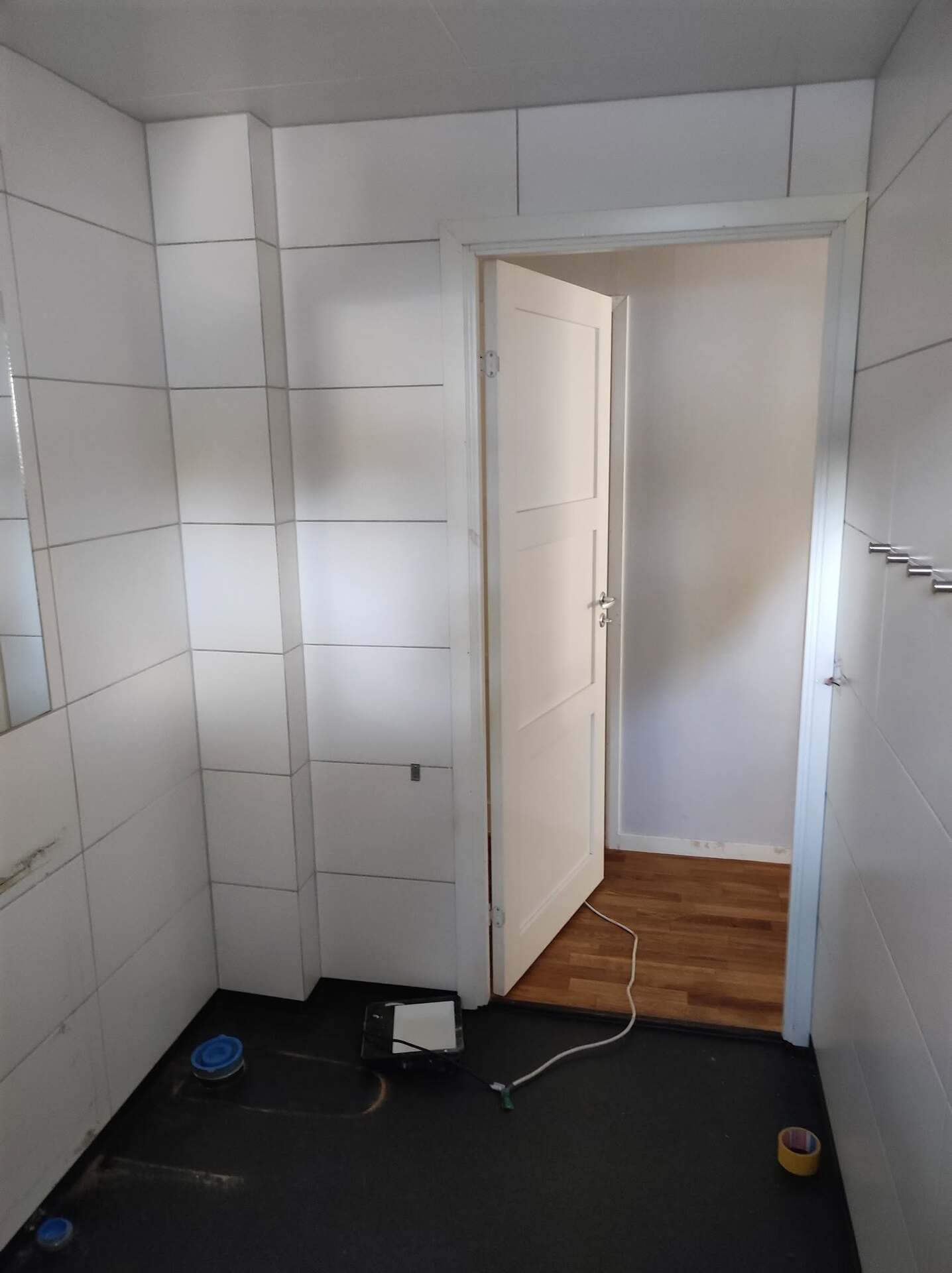 Badrum under renovering med gipsskivor och dörröppning