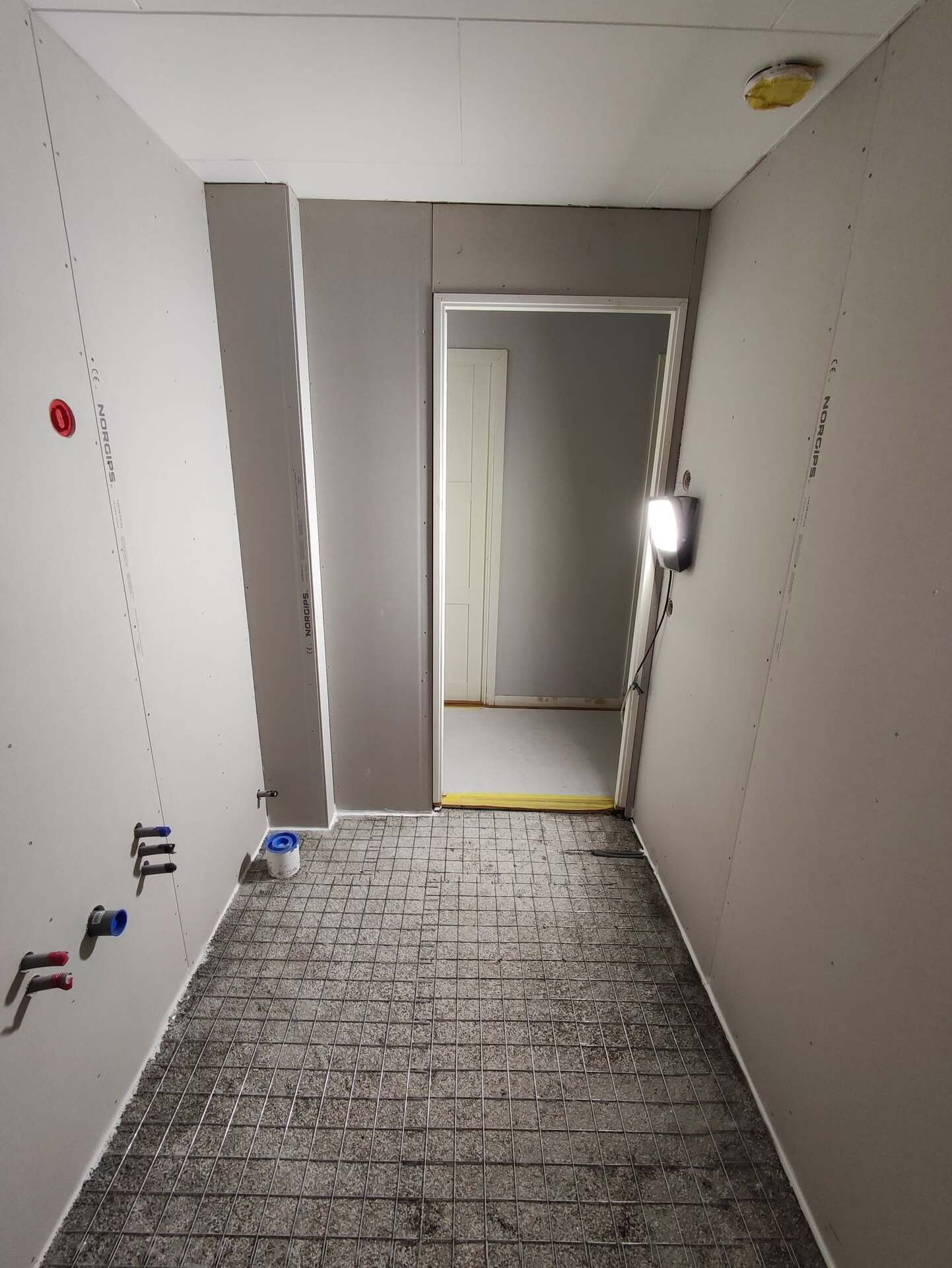 Badrum under renovering med gipsskivor och nätarmerat golv inför plattsättning