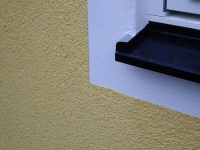Putsfasad i hörnparti med fönsterbleck i plåt