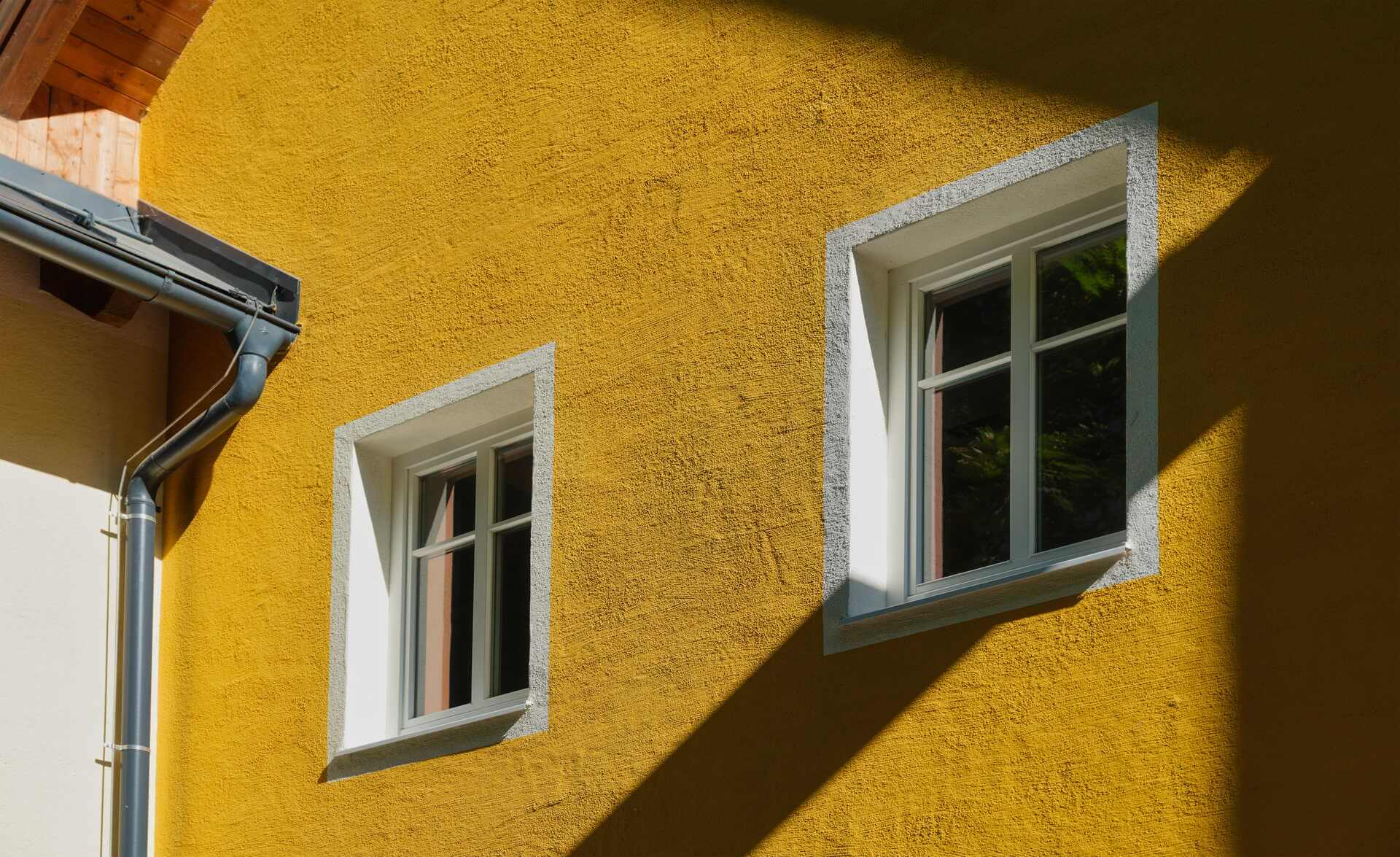 Putsfasad i gult med vitmålade fönsteromfattningar