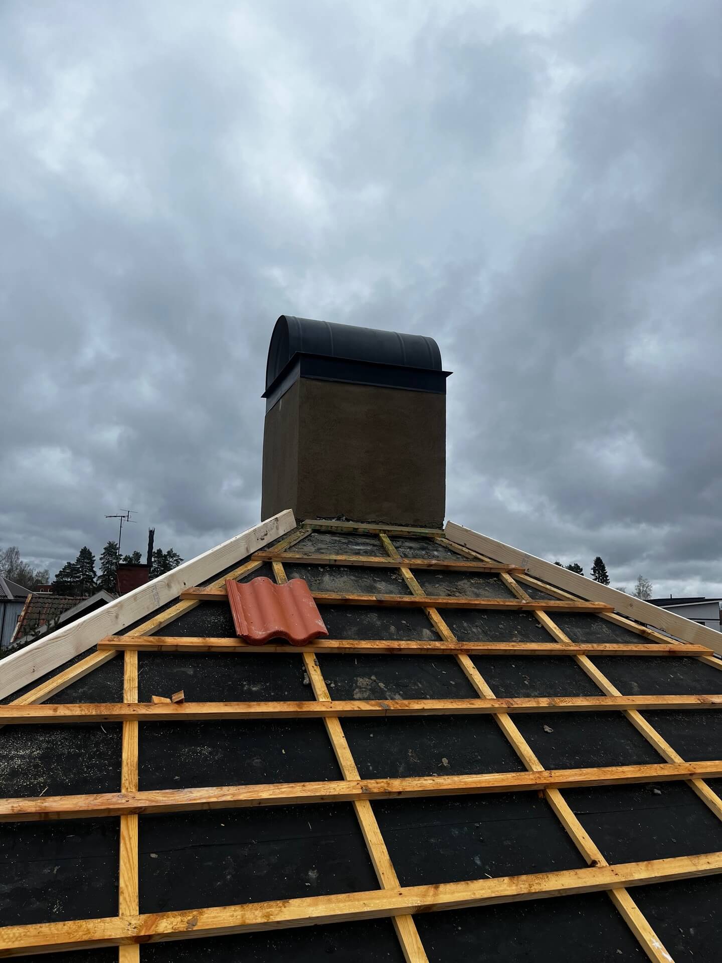 Tak under renovering med råspont, ny taktäckning och skorsten