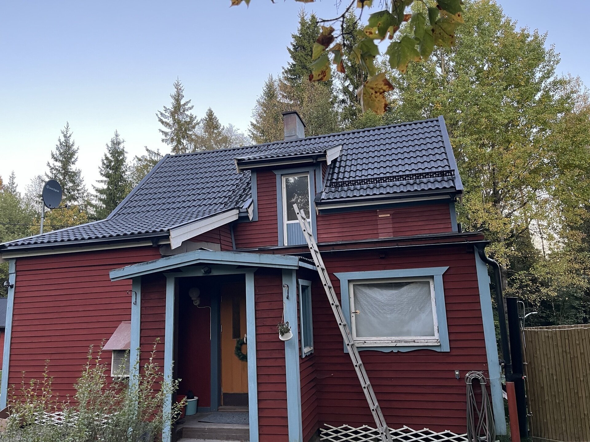 Rödmålat hus med nytt takmaterial sett från framsidan