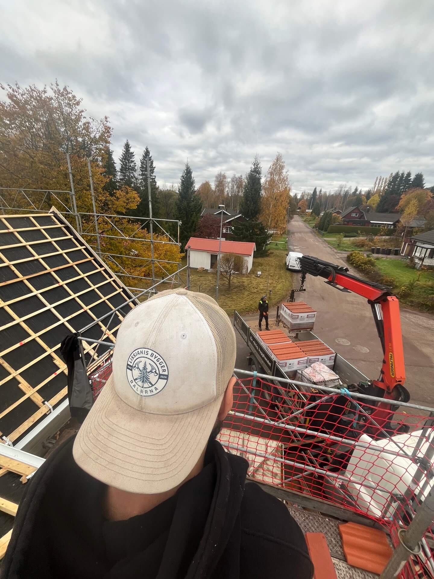 Vy över takkonstruktion och bostadsområde från takarbetsplats