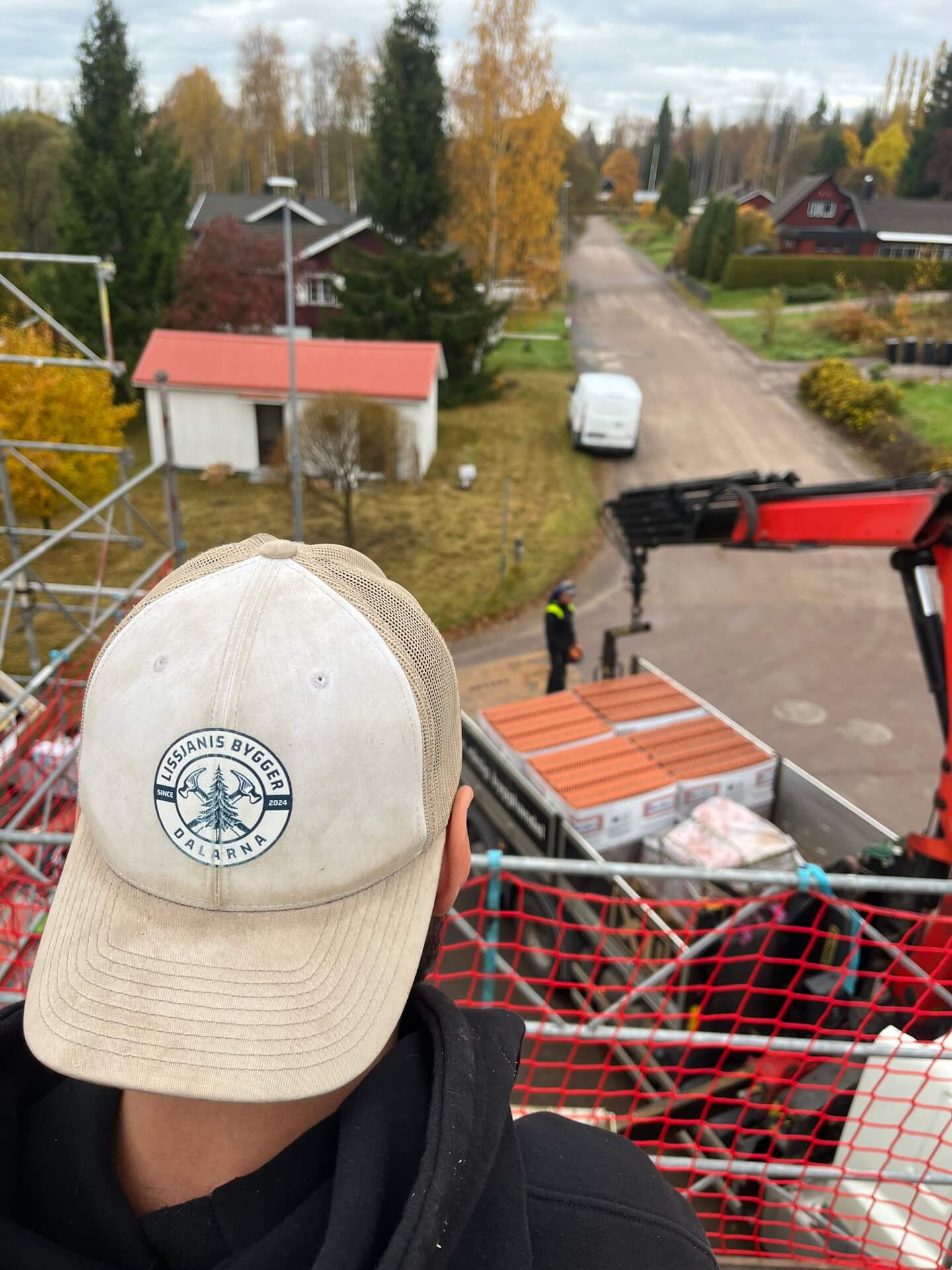 "Utsikt över tak från arbetsplatsen med Lissjanis Byggers keps i förgrunden