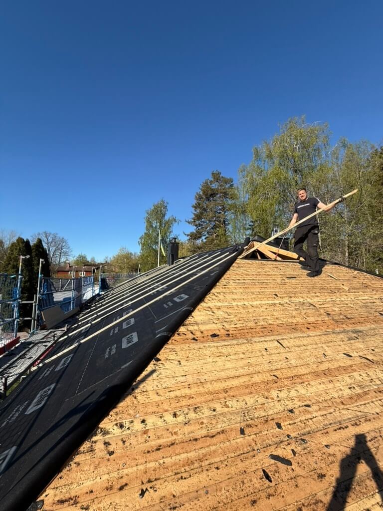 Montör som arbetar på tak med lagd underlagspapp inför taktäckning