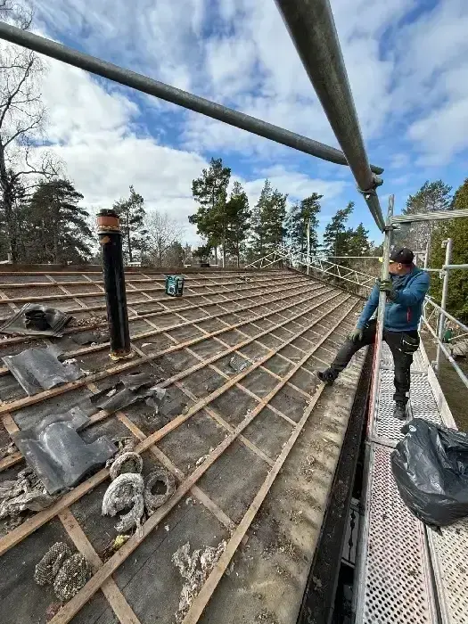 Montör som arbetar på tak med öppen råspont och ventilationsrör