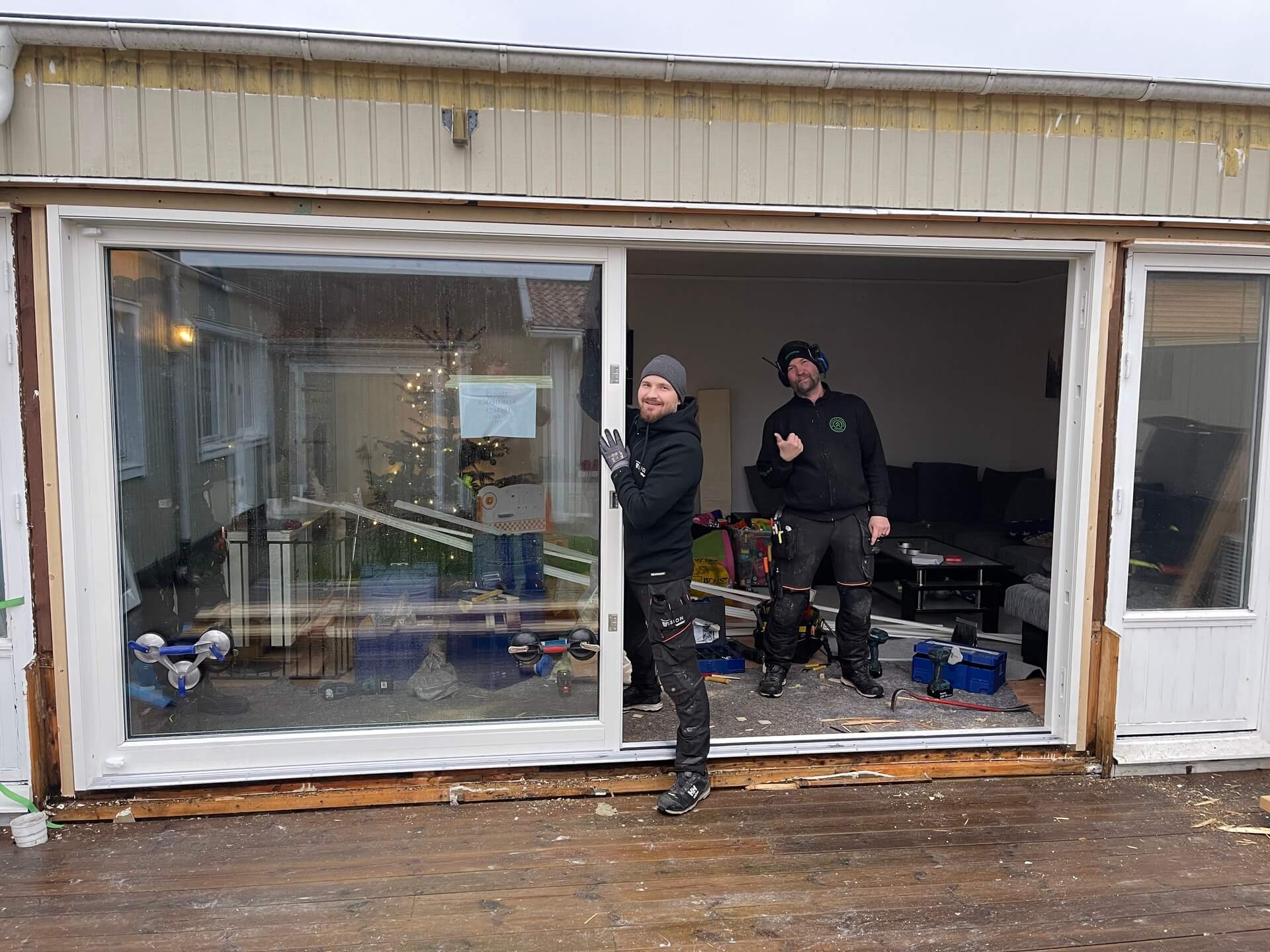 Två montörer från Vision Entreprenad framför nyinstallerat skjutparti mot altan