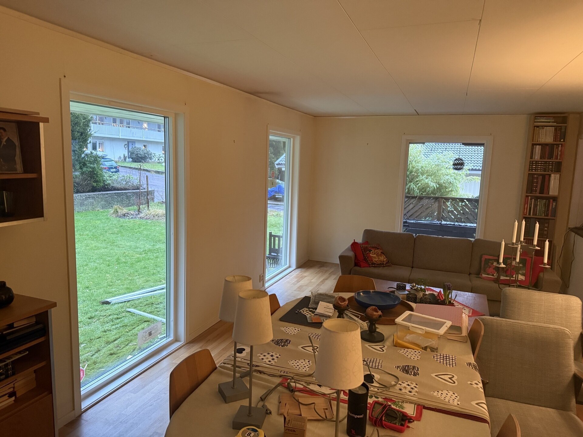 Nyinstallerat liggande fönster och sidofönster i vardagsrum med trädgårdsutsikt