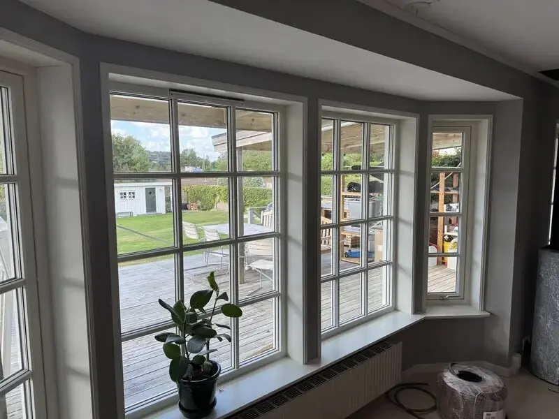 Vit villa med nya spröjsade fönster och stort glasparti
