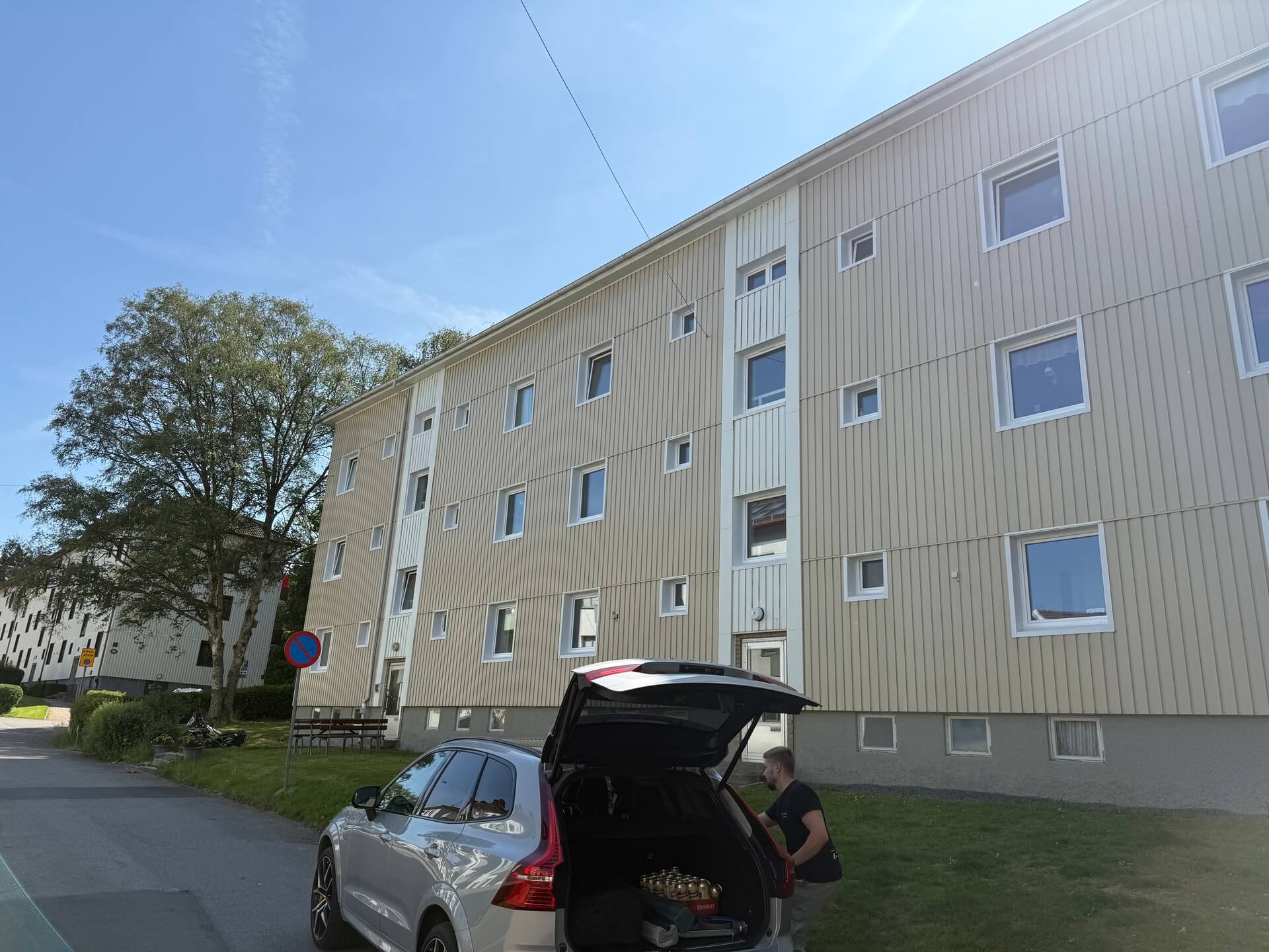Ljusbeige flerbostadshus med nyinstallerade vita fönster i flera storlekar
