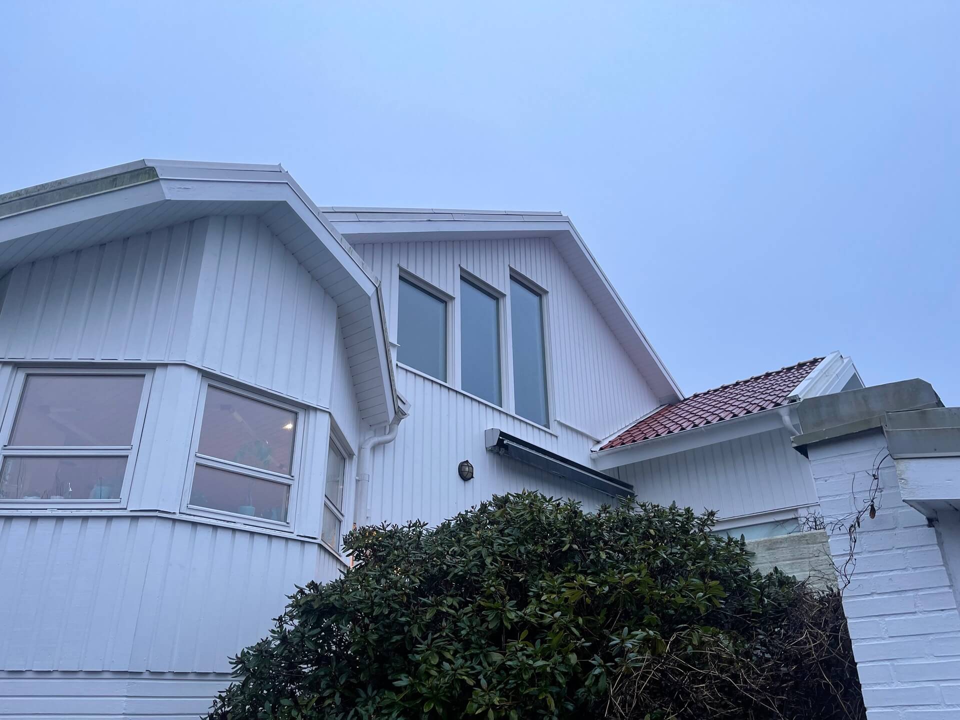 Vit villa med nyinstallerade fönster i gavelspets och takkupa