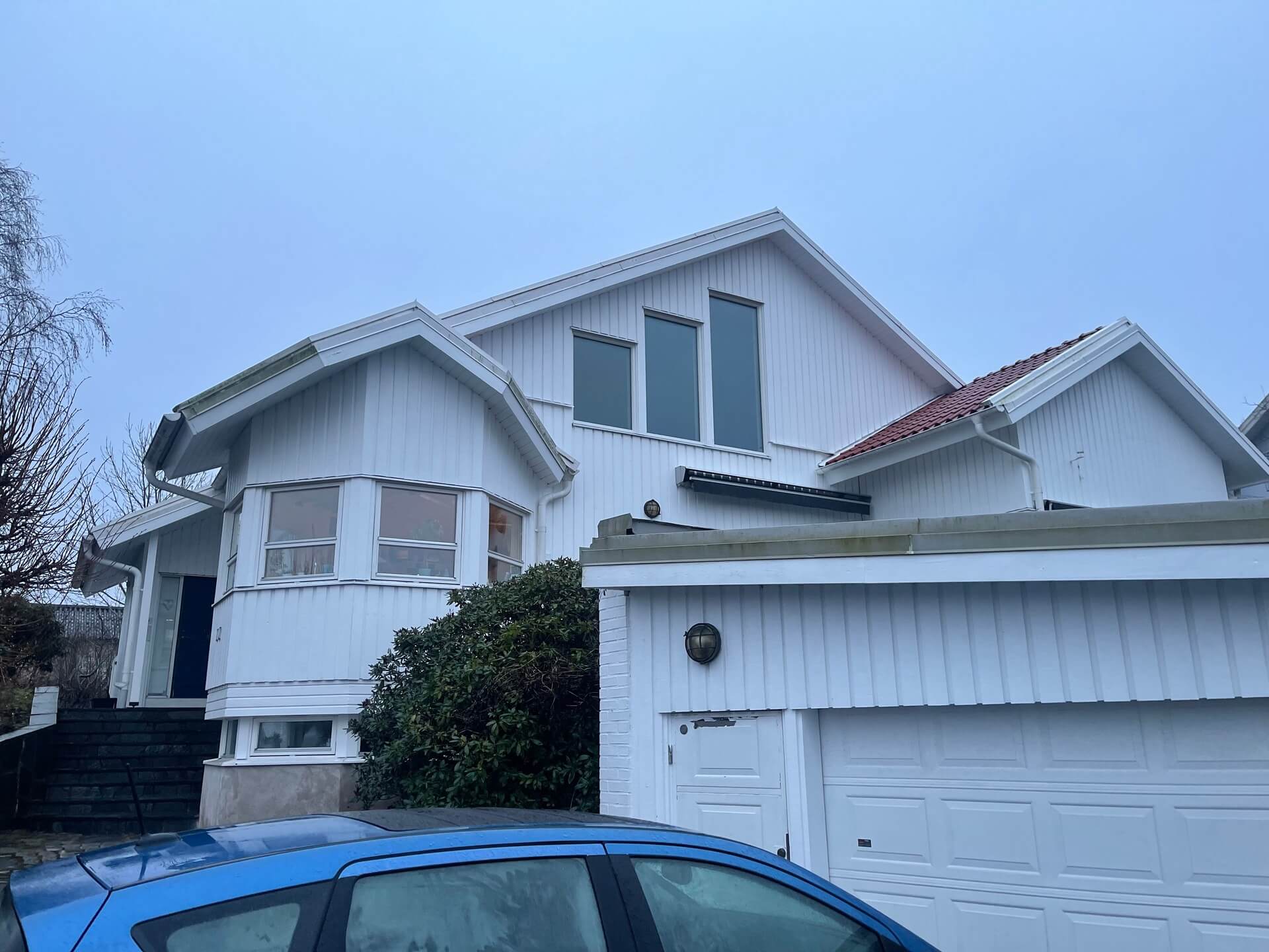 Vit villa med nyinstallerade fönster i takkupa och garage