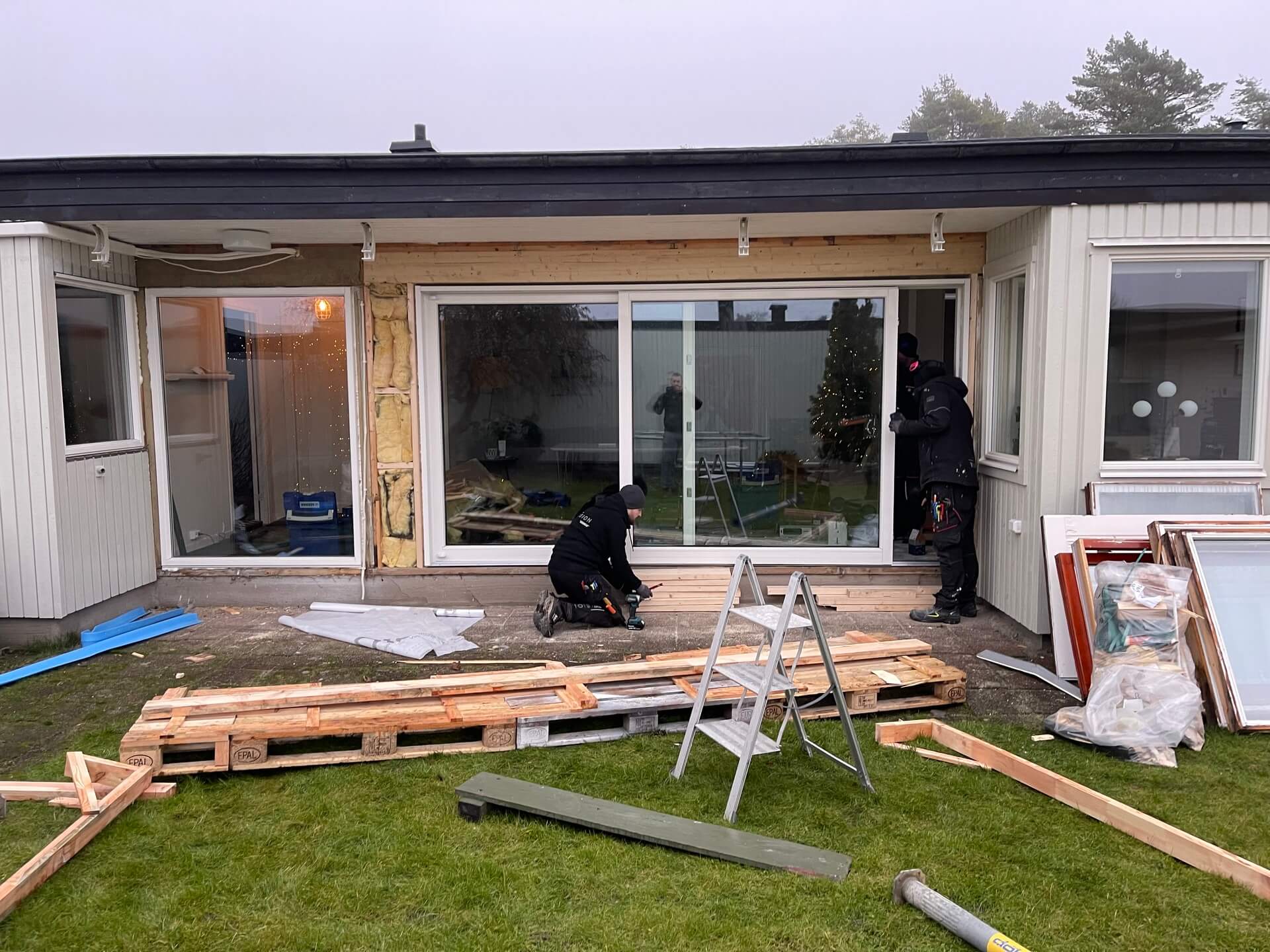 Montörer installerar nya skjutpartier på enplansvilla under pågående arbete