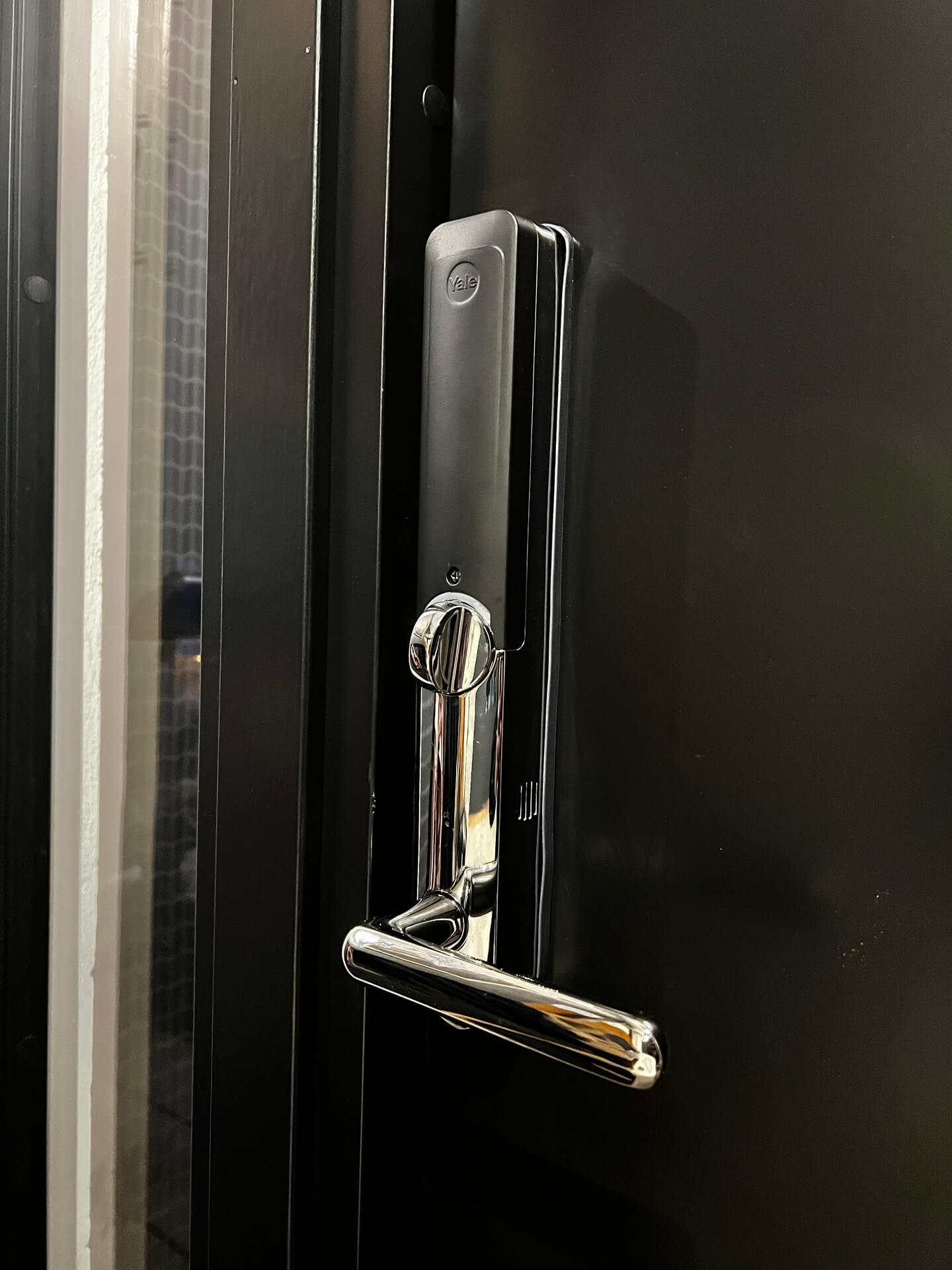 Närbild på handtag och tätningslister på nyinstallerad mörk ytterdörr