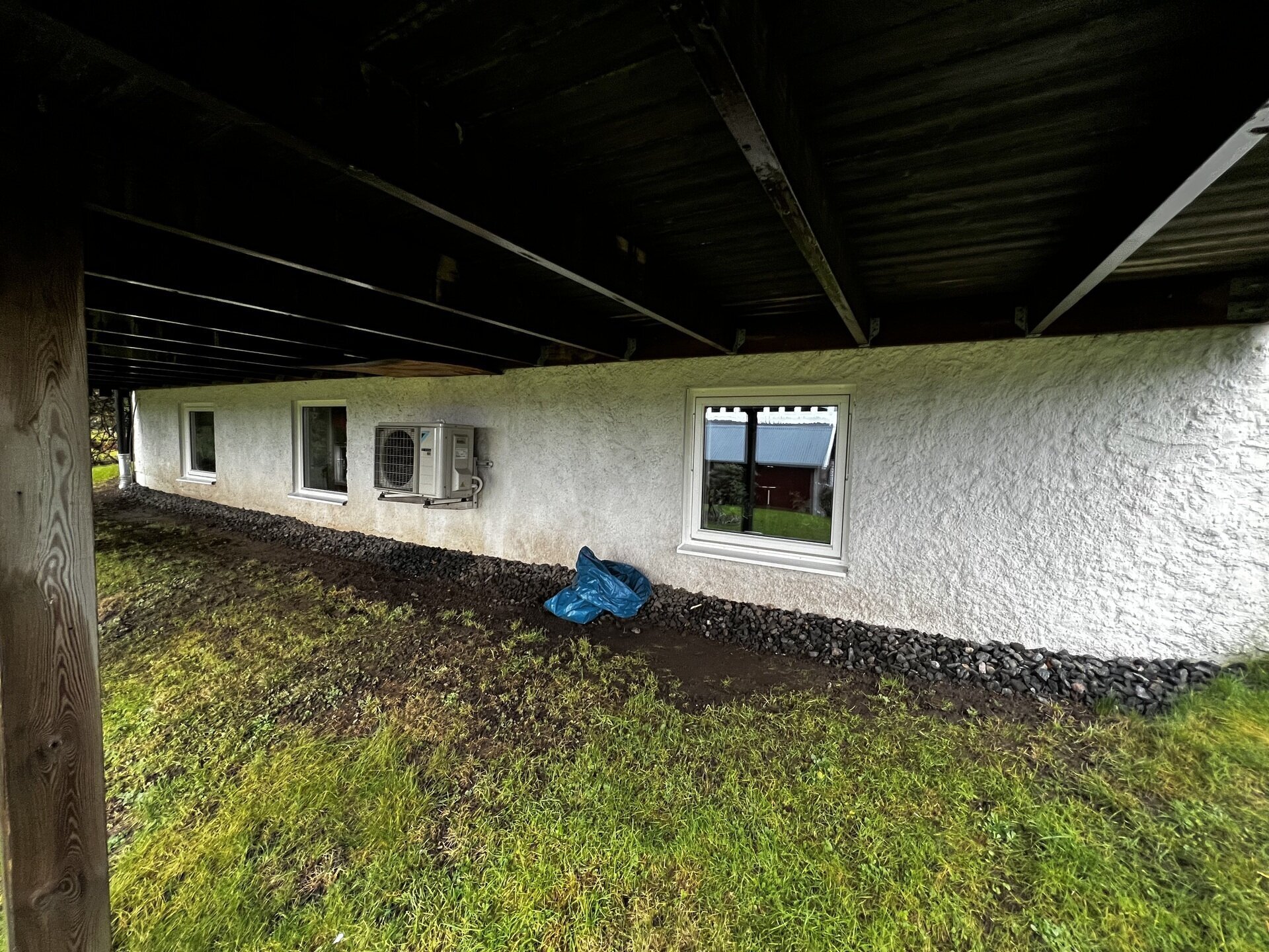 Nyinstallerade källarfönster med vita karmar i putsad husgrund