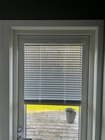Närbild på nyinstallerat fönster med integrerade persienner mellan glasen