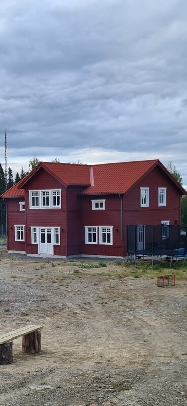 Röd tvåvåningsvilla med nytt rött plåttak och vita fönsterfoder