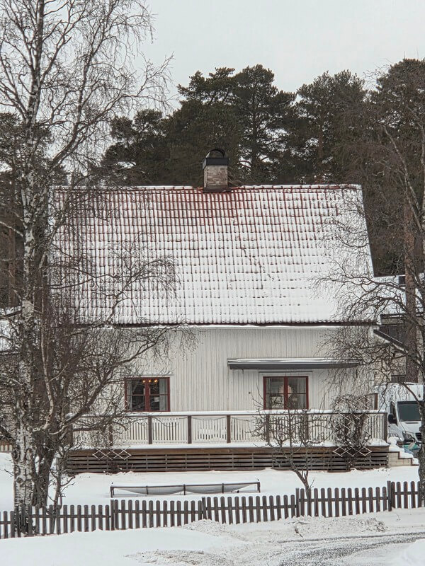 Villa med snötäckt och slitet tak fotograferat från drönare i vintermiljö