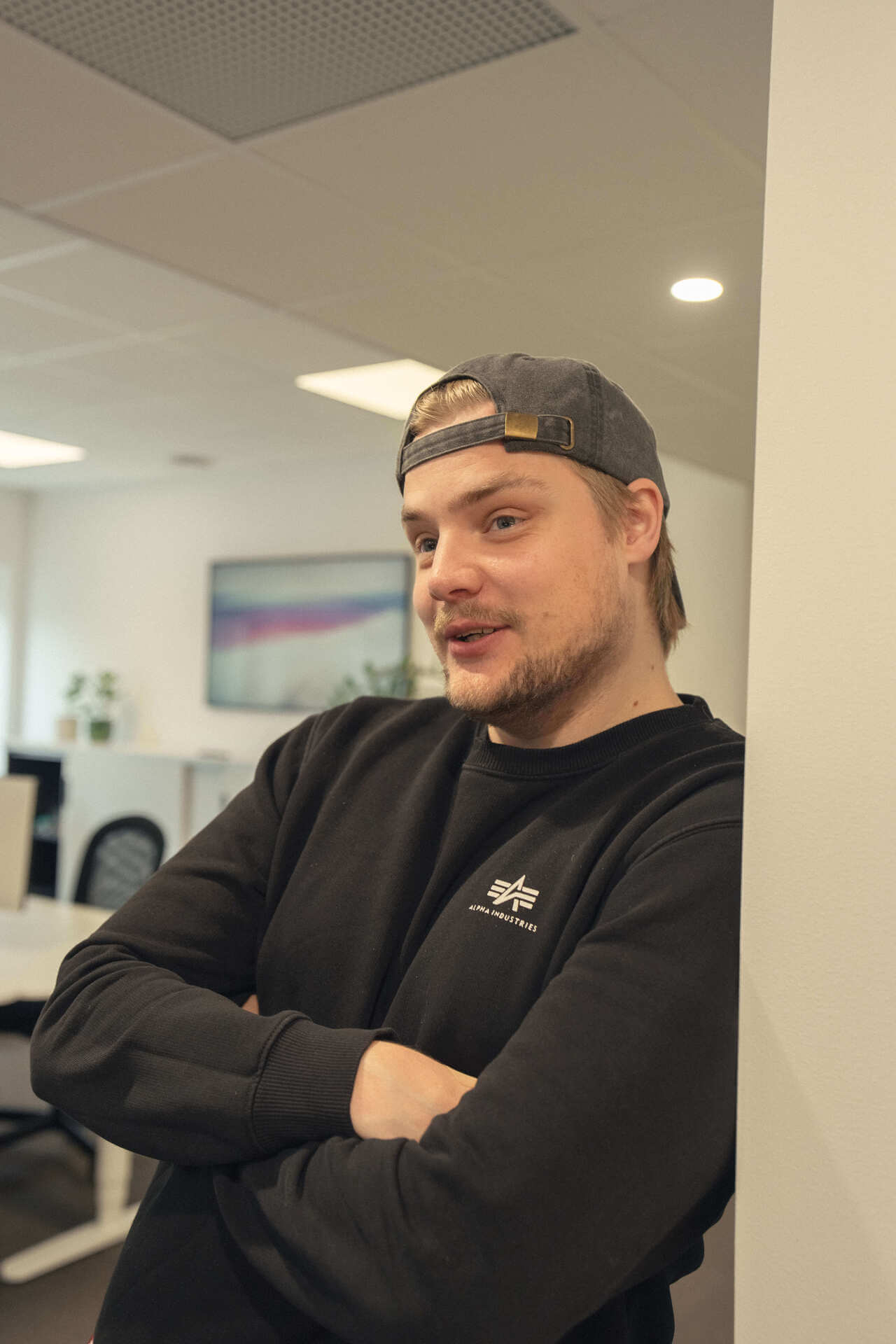 Olof Hag står med armarna i kors i kontorslandskapet