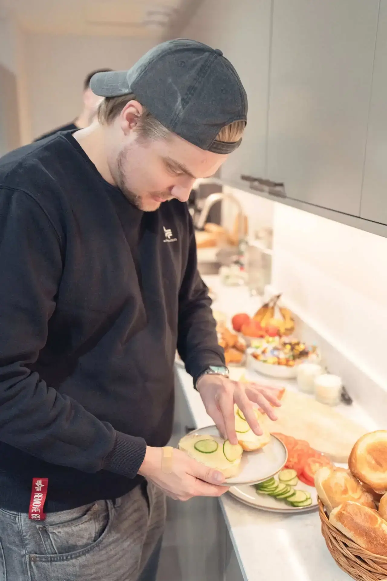 Kollega med keps gör mackor i köket
