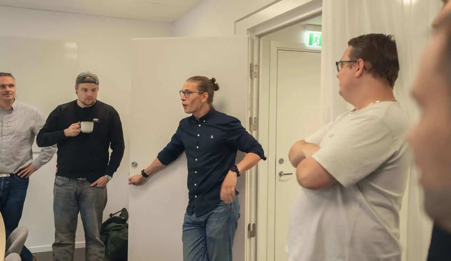 Kollegor i samtal vid dörren till mötesrummet