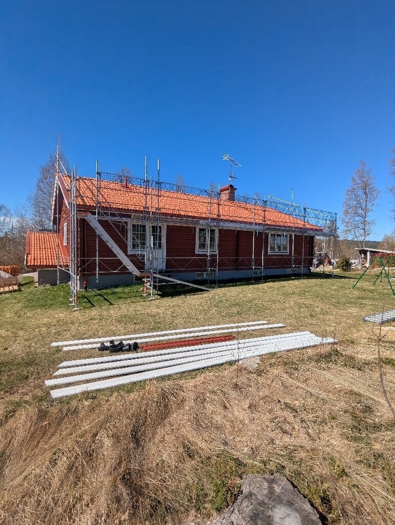 Röd villa med ställning under takbyte i Åkersbodarna, Leksand