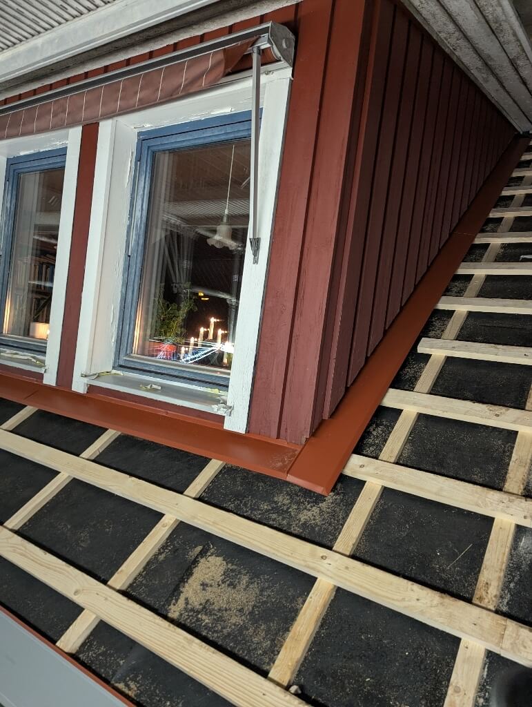 Takstege vid röd fasad – Anders Lars gata i Borlänge, takbyte av Sol och Tak Dalarna