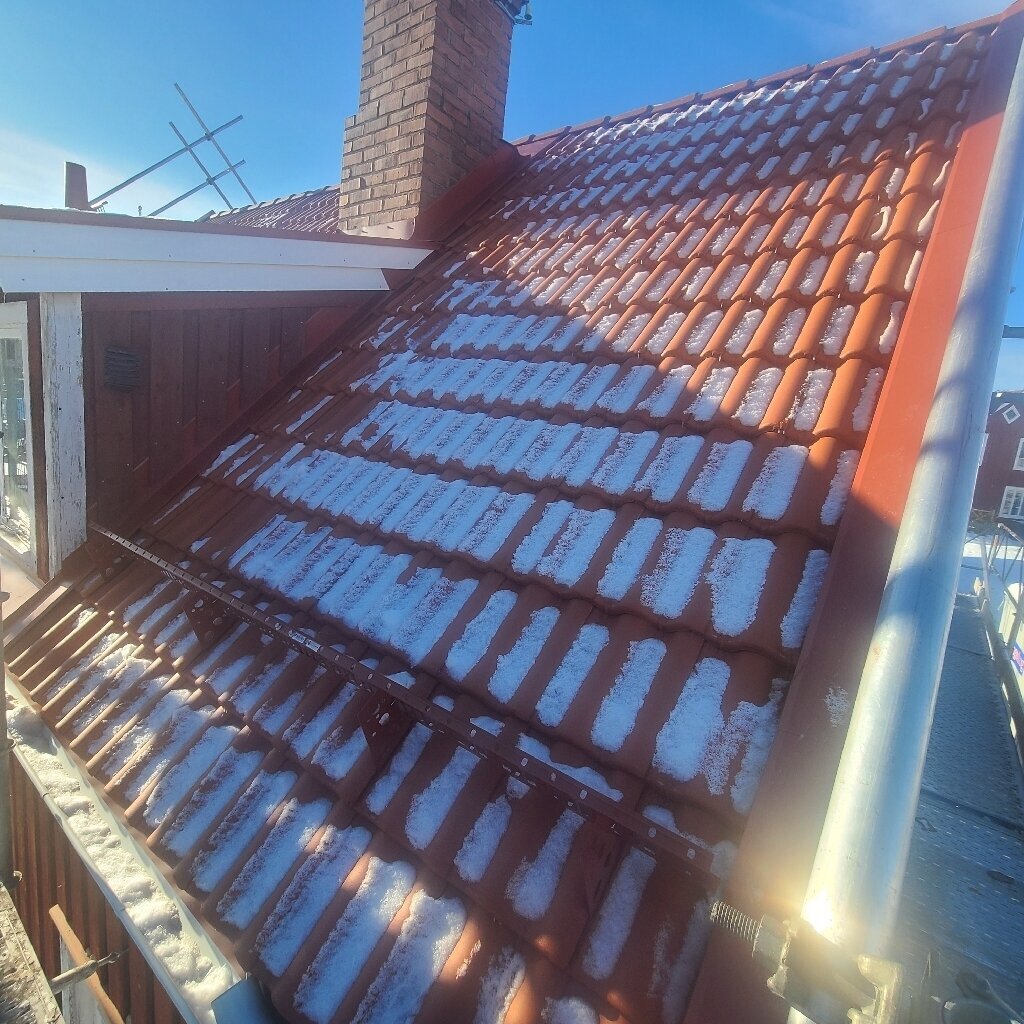 Nytt tak med röda takpannor i snö i Insjön, Leksand