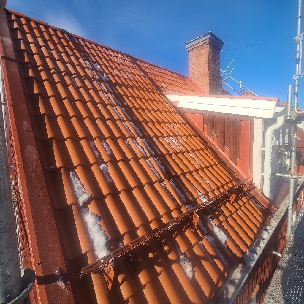 Röda takpannor läggs vid skorsten i Insjön, Leksand