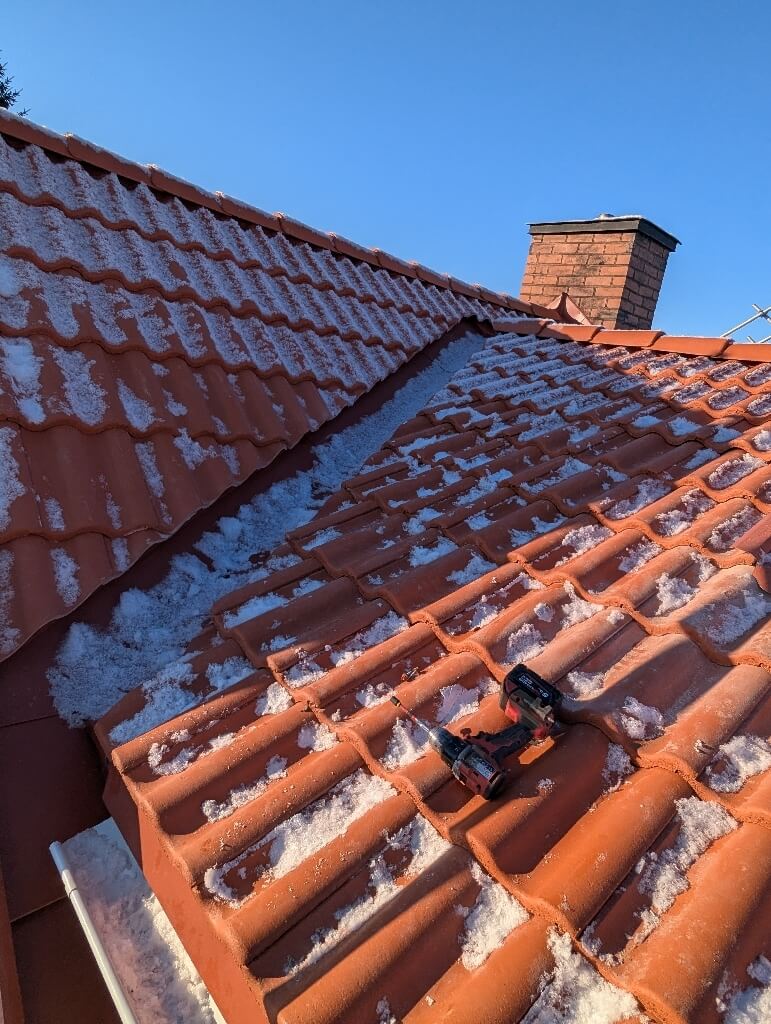 Röda tegelpannor, skorsten, snötäckt – Örjansgatan i Borlänge, takbyte av Sol och Tak Dalarna