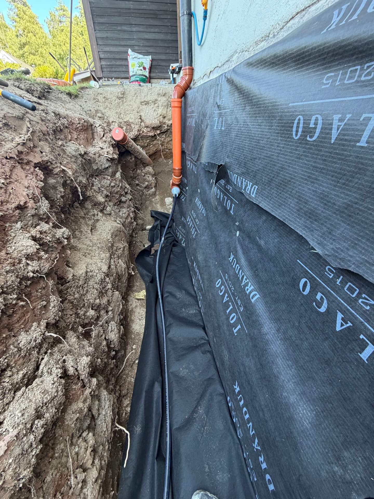 Grundisolering och dräneringsrör i öppen schakt vid dränering i Karlskoga