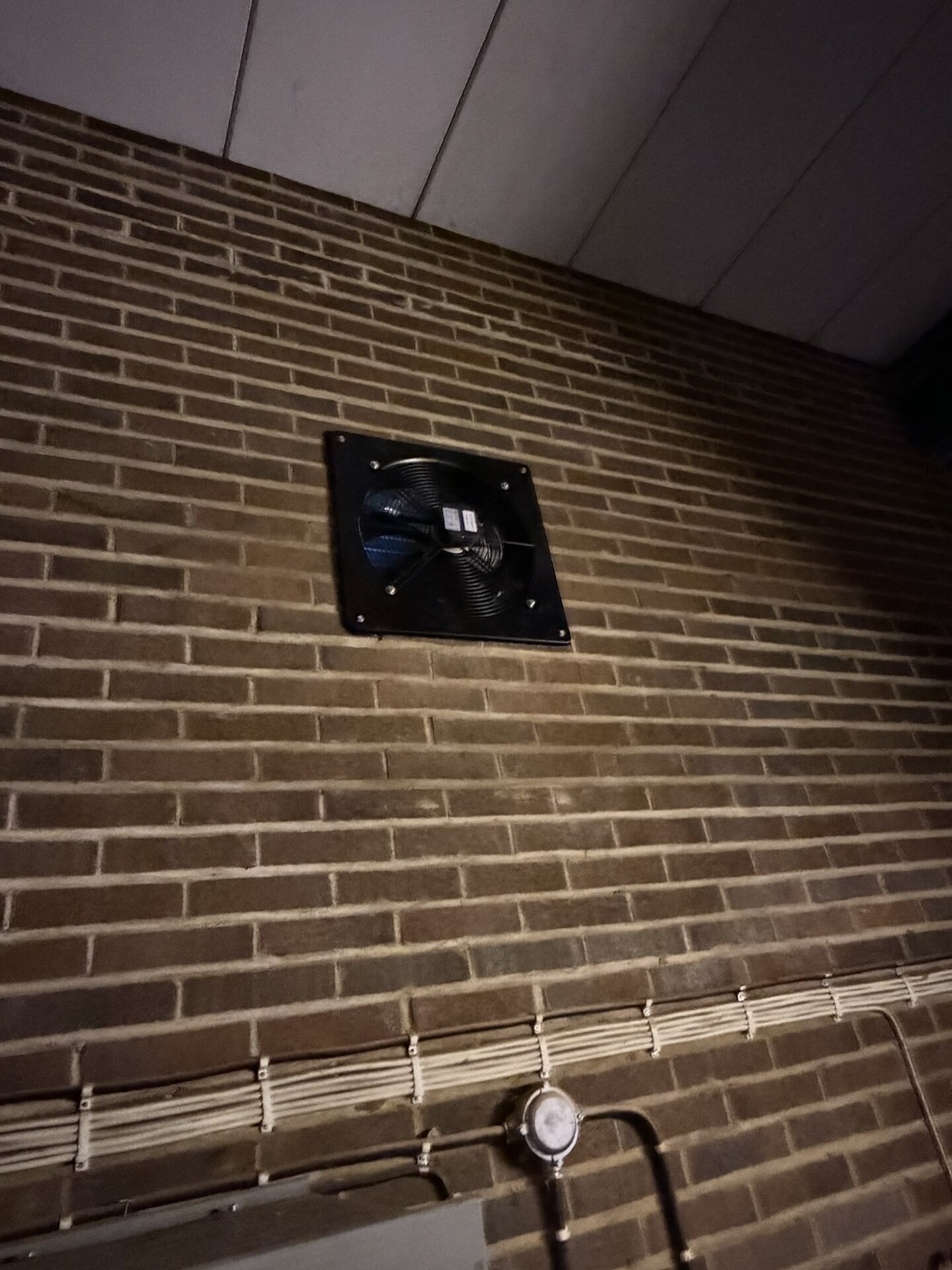 Monterad väggfläkt i tegelfasad vid ventilationsmontering i Alster