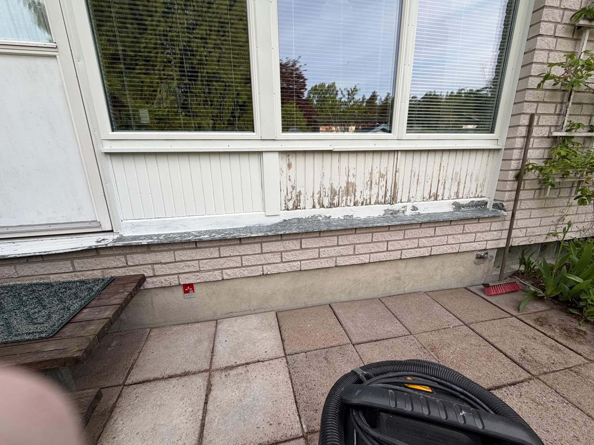 Vit träpanel under fönster under fasadrenovering i Stockfallet