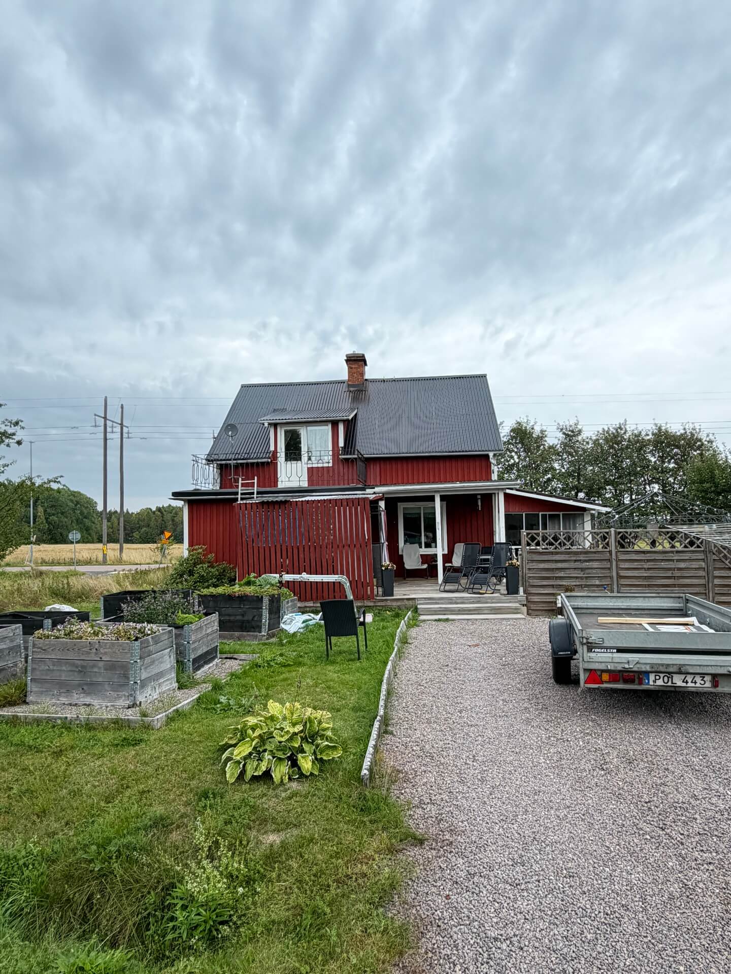 Röd villa med grusuppfart före takbyte i Ulvsby