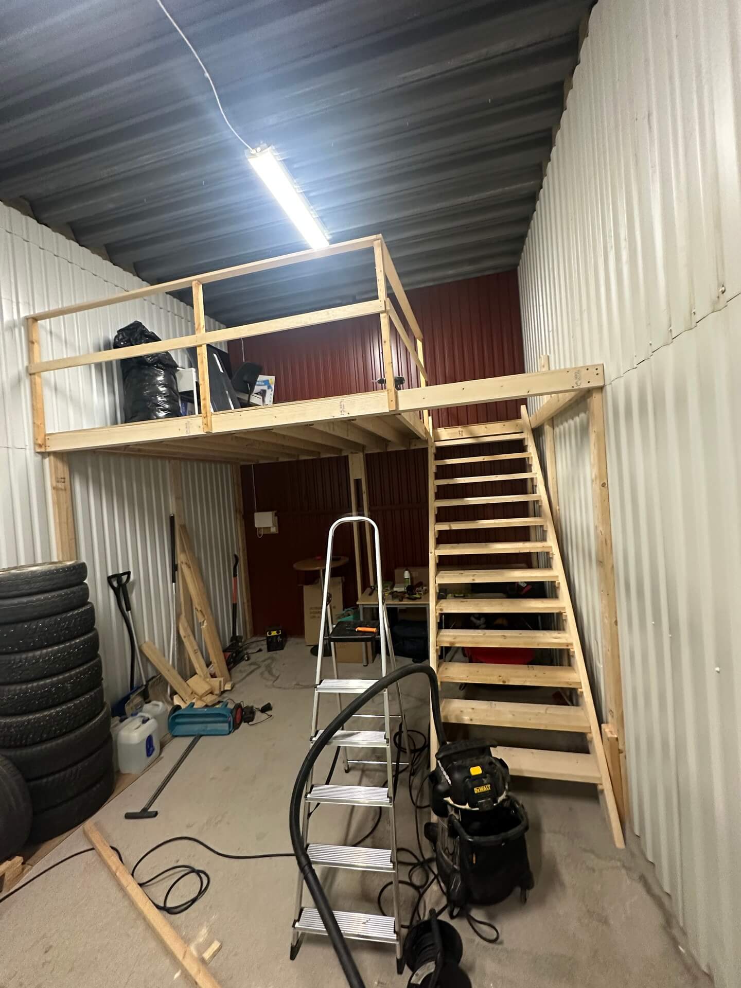 Nybyggt loft i trä med trappa i ett förråd i Valsviken