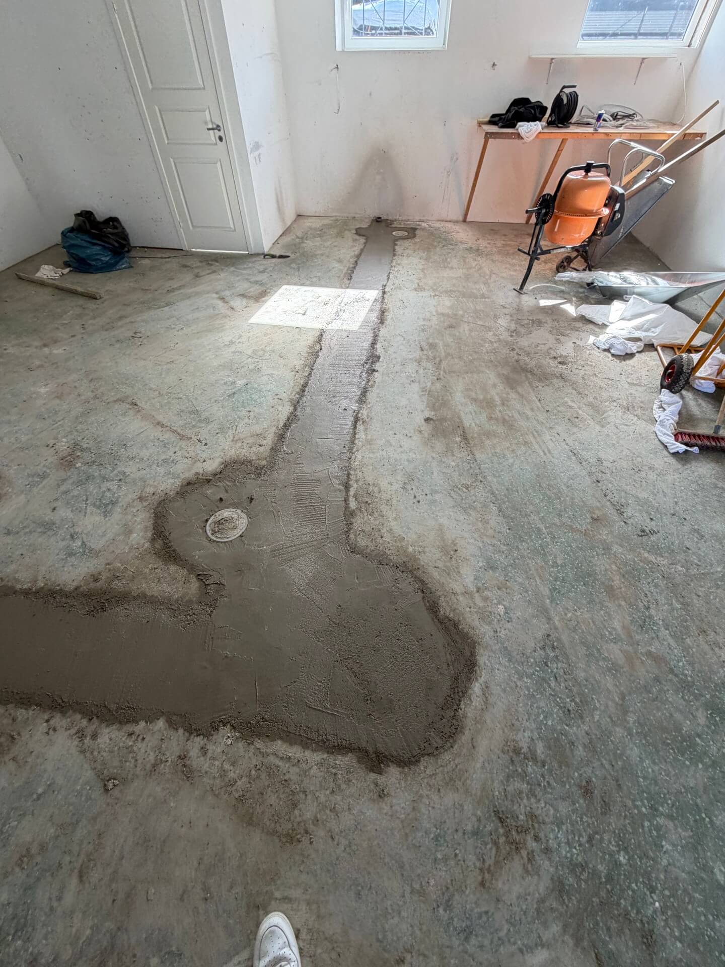 Nygjutna betongrännor i ett golv under betonggjutning i Alster