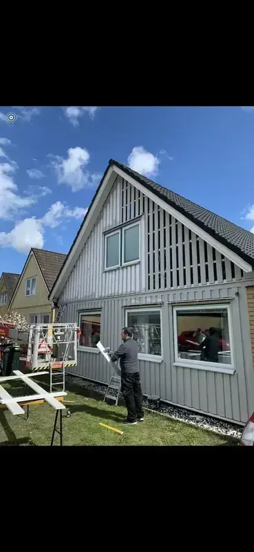 Fasadrenovering av en villa med ny stående träpanel